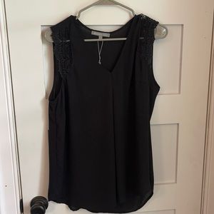 Sleeveless black blouse with should detail.